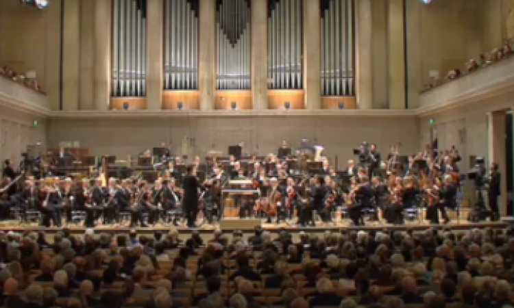 Μια συμφωνική ορχήστρα εκπλήσσει τον μαέστρο στα γενέθλια του ενώπιον κοινού.